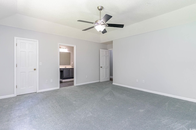 unfurnished bedroom with carpet, vaulted ceiling, ensuite bath, and ceiling fan