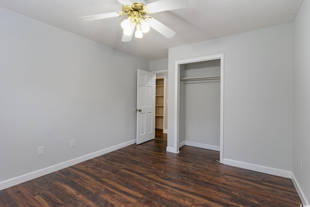 unfurnished bedroom featuring ceiling fan, dark hardwood / wood-style flooring, a textured ceiling, and a closet