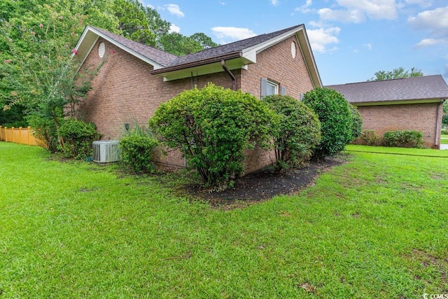 view of home's exterior featuring central AC unit and a yard