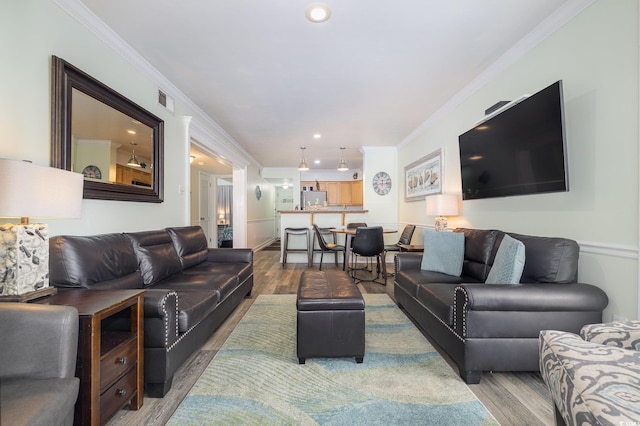 living room featuring hardwood / wood-style flooring and crown molding