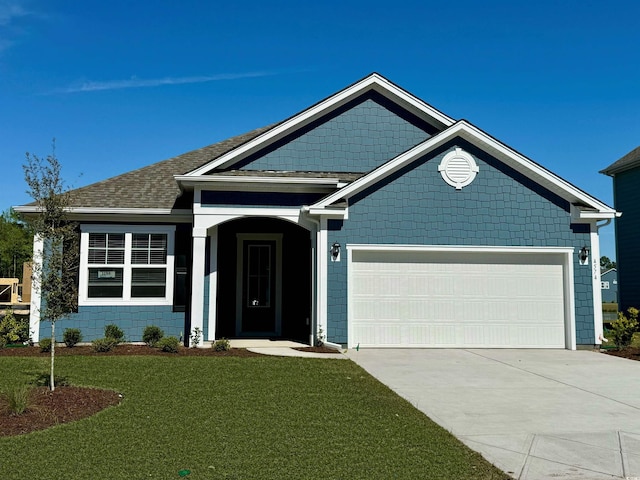 craftsman-style home featuring a garage and a front lawn