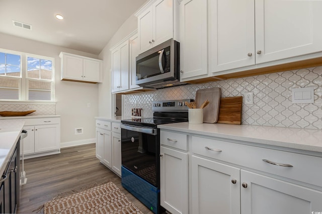 kitchen featuring white cabinets, decorative backsplash, black electric range oven, and dark hardwood / wood-style floors