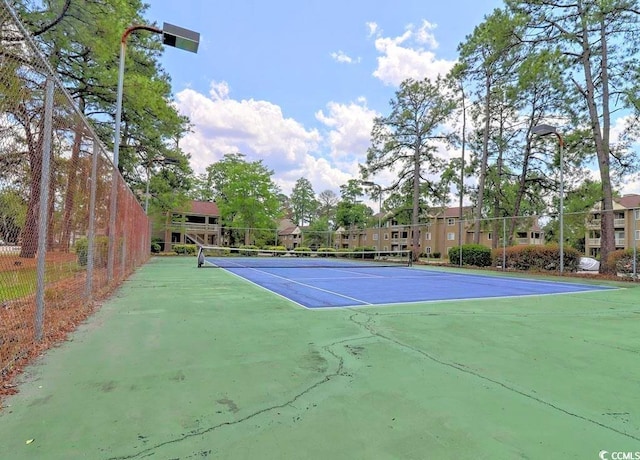 view of tennis court with basketball hoop