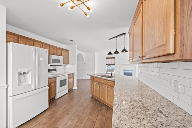 kitchen featuring sink, hanging light fixtures, tasteful backsplash, light hardwood / wood-style floors, and white appliances