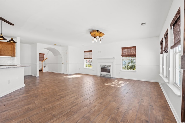 unfurnished living room featuring dark hardwood / wood-style floors and a high end fireplace