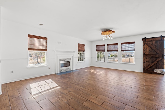 unfurnished living room featuring a barn door and hardwood / wood-style floors