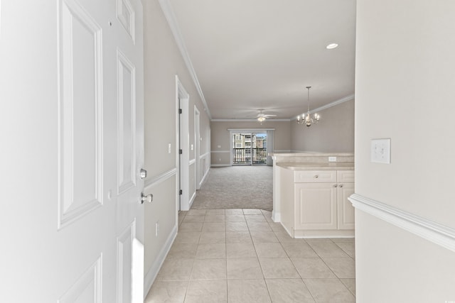 hallway with an inviting chandelier, ornamental molding, and light tile patterned flooring