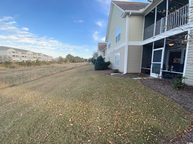 view of property exterior featuring a lawn and a balcony