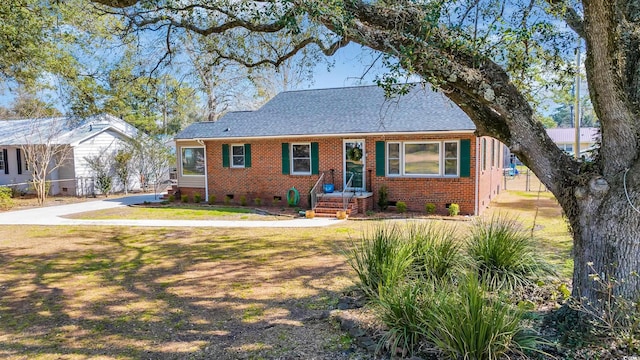 view of front of house featuring brick siding, crawl space, a shingled roof, and a front lawn