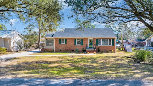 view of front of property with brick siding, a shingled roof, a front yard, crawl space, and fence