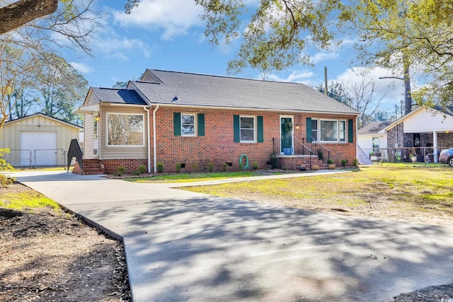 view of front facade featuring an outbuilding, a garage, brick siding, fence, and crawl space