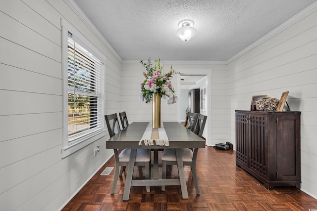 dining room featuring visible vents, a textured ceiling, and ornamental molding