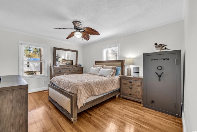 bedroom with light wood finished floors, a textured ceiling, and crown molding