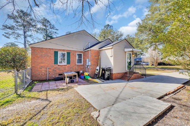 back of house with a patio area, fence, and brick siding