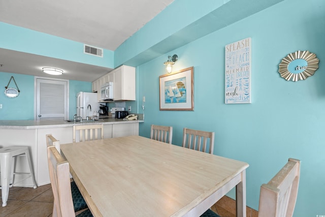 dining area featuring light tile patterned floors and sink