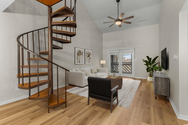 living room with light wood-type flooring, high vaulted ceiling, and ceiling fan