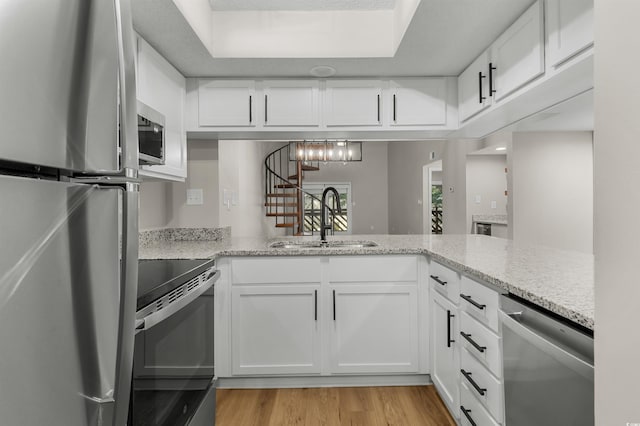 kitchen featuring light stone countertops, white cabinetry, sink, and appliances with stainless steel finishes