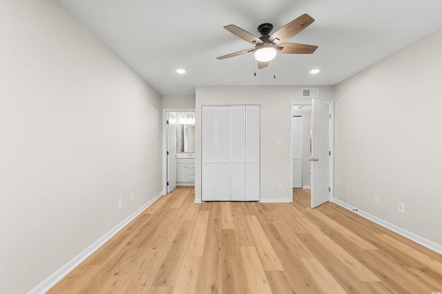 unfurnished bedroom featuring a closet, ensuite bathroom, ceiling fan, and light hardwood / wood-style floors