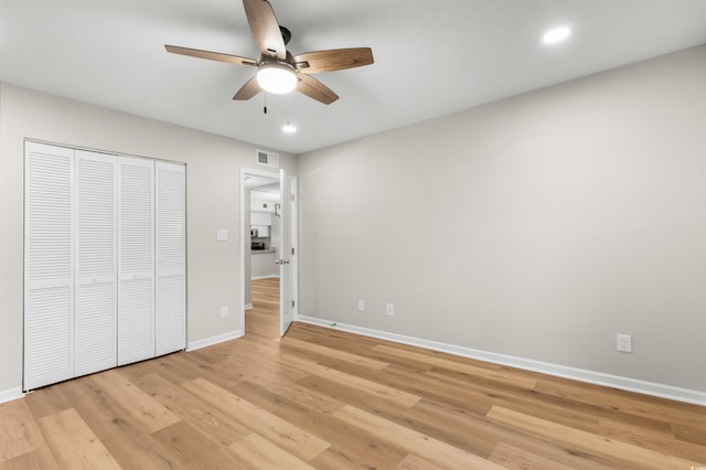 unfurnished bedroom with ceiling fan, a closet, and light wood-type flooring