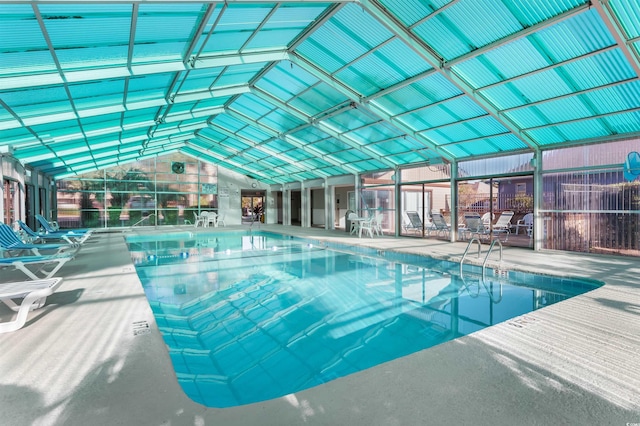 view of swimming pool with glass enclosure and a patio area