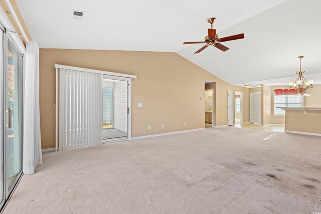 unfurnished living room with light carpet, ceiling fan with notable chandelier, and lofted ceiling