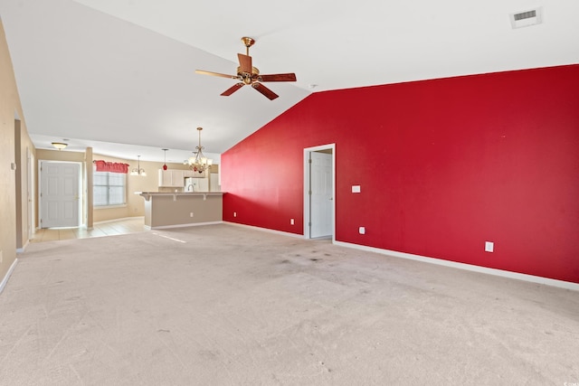 interior space featuring ceiling fan with notable chandelier, light colored carpet, and vaulted ceiling