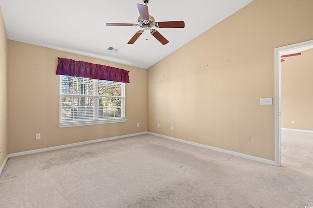 empty room with light colored carpet, vaulted ceiling, and ceiling fan