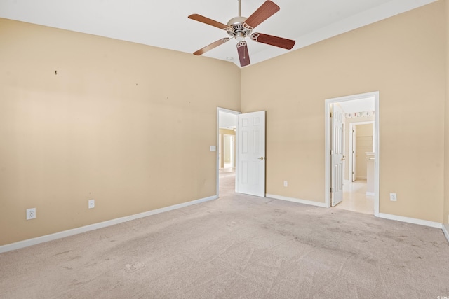 interior space featuring a high ceiling, ensuite bathroom, ceiling fan, and light colored carpet