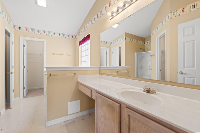 bathroom with tile patterned flooring, vanity, a shower with shower door, and lofted ceiling