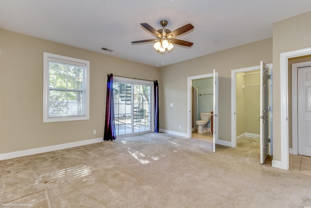 unfurnished bedroom with access to outside, connected bathroom, ceiling fan, and light colored carpet