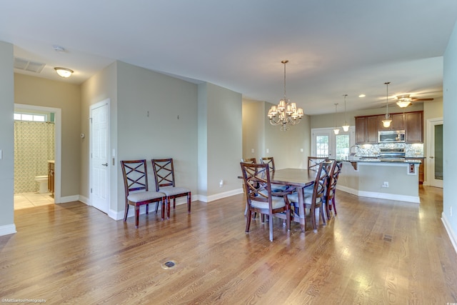 dining space featuring light hardwood / wood-style flooring and an inviting chandelier