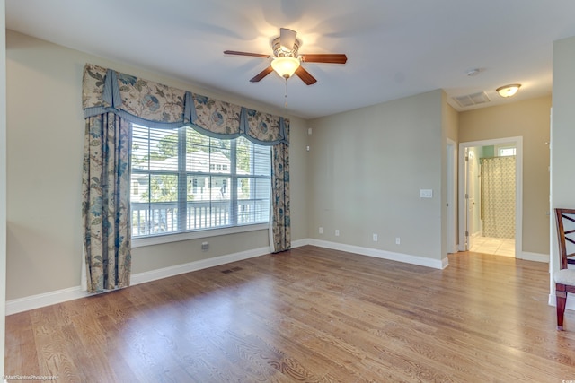 empty room with hardwood / wood-style floors and ceiling fan