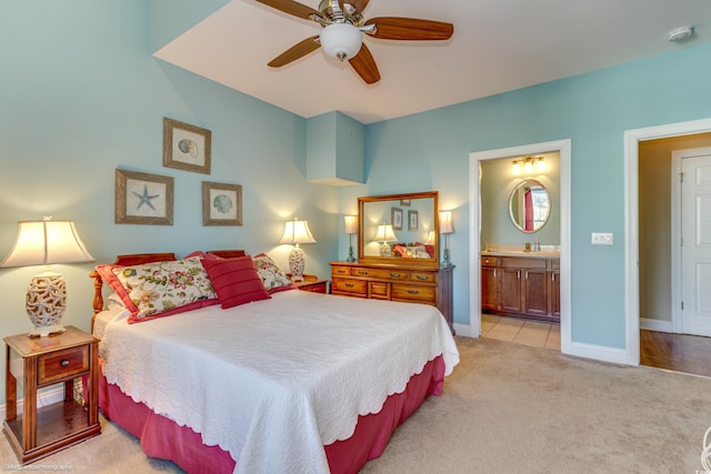 bedroom with sink, light colored carpet, ceiling fan, and ensuite bathroom