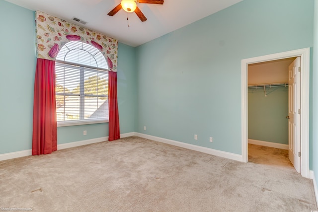 carpeted spare room with ceiling fan