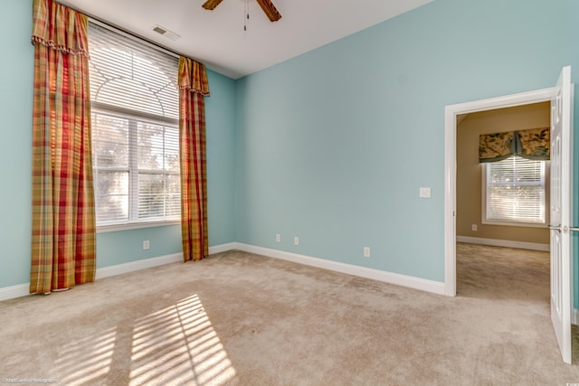 unfurnished room with plenty of natural light and light carpet