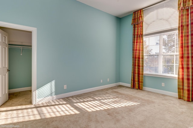 unfurnished bedroom with a closet and light colored carpet