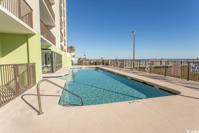 view of swimming pool with a patio and a water view