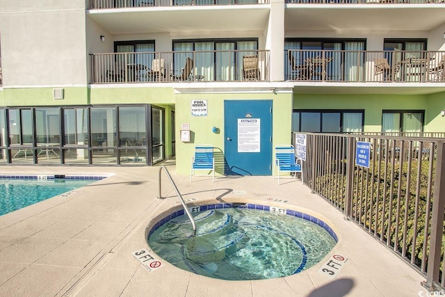 view of pool with a hot tub