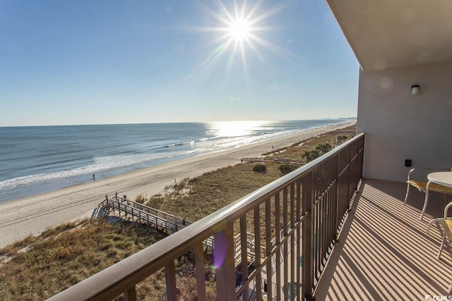 balcony featuring a water view and a beach view