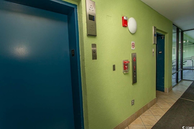 corridor with light tile patterned floors and elevator