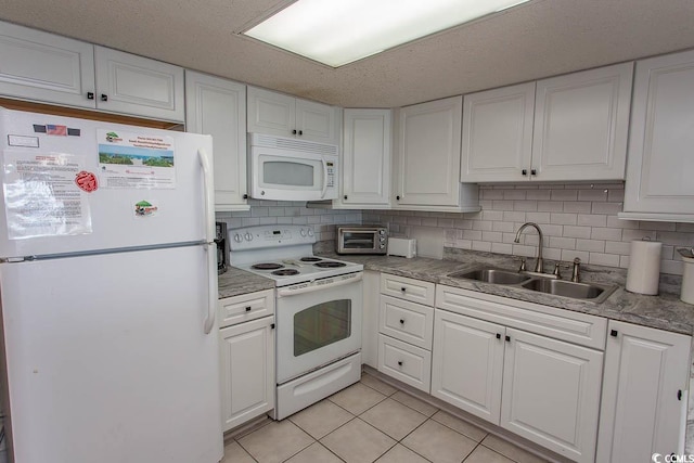 kitchen with backsplash, white cabinetry, sink, and white appliances