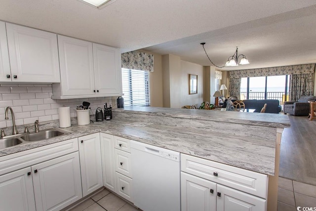 kitchen featuring dishwasher, kitchen peninsula, and sink