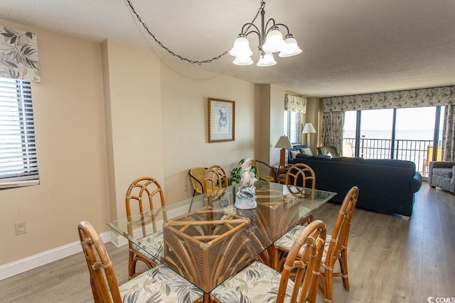 dining room with hardwood / wood-style floors, a notable chandelier, and a textured ceiling