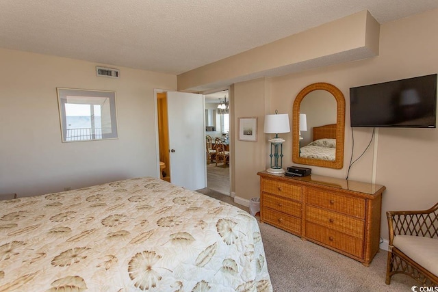 bedroom featuring light colored carpet and a textured ceiling