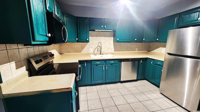 kitchen with stainless steel appliances, blue cabinets, light countertops, and a sink