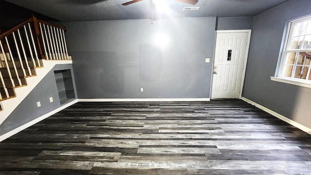 foyer featuring baseboards, visible vents, a ceiling fan, dark wood-style floors, and stairway