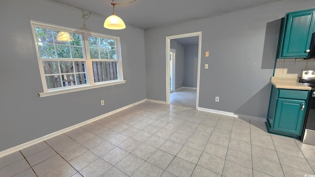 unfurnished dining area featuring light tile patterned floors and baseboards