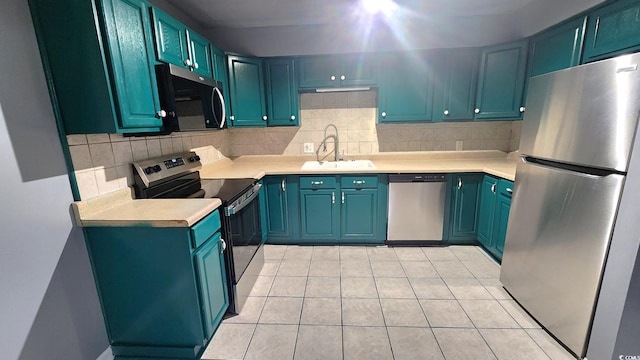 kitchen with a sink, decorative backsplash, stainless steel appliances, and light countertops