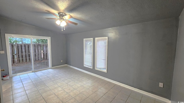 unfurnished room with ceiling fan, vaulted ceiling, light tile patterned flooring, and baseboards