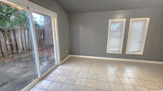 unfurnished room with light tile patterned flooring and baseboards